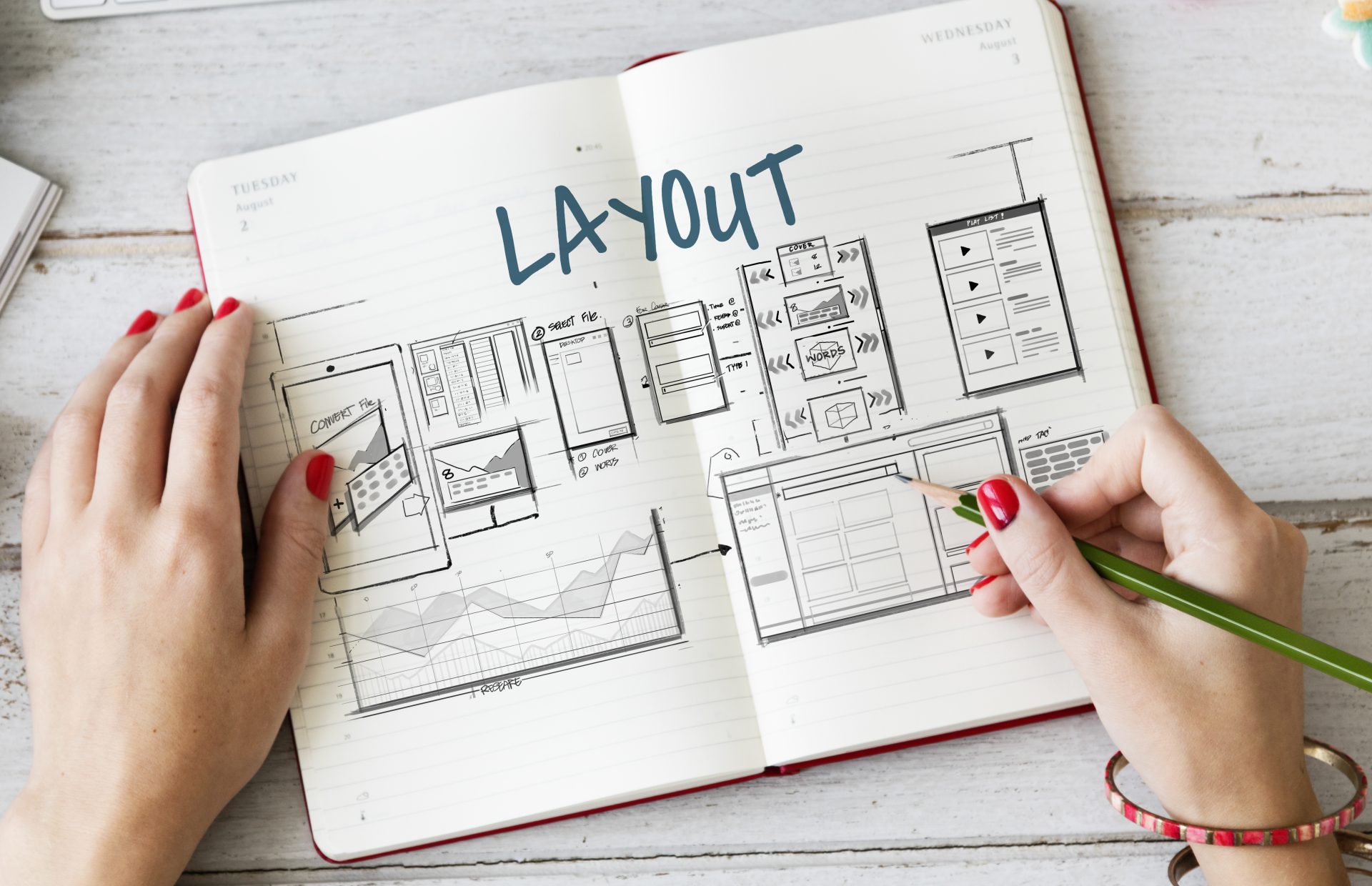 A person drawing a sketch of what the layout of a website would look like.